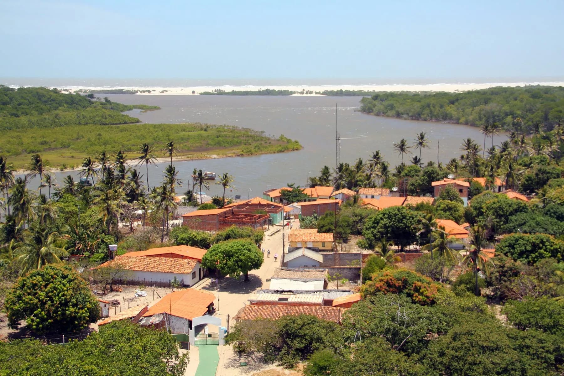 Vista de Mandacaru com casas, coqueiros, rio e praia no Passeio ao Farol de Mandacaru