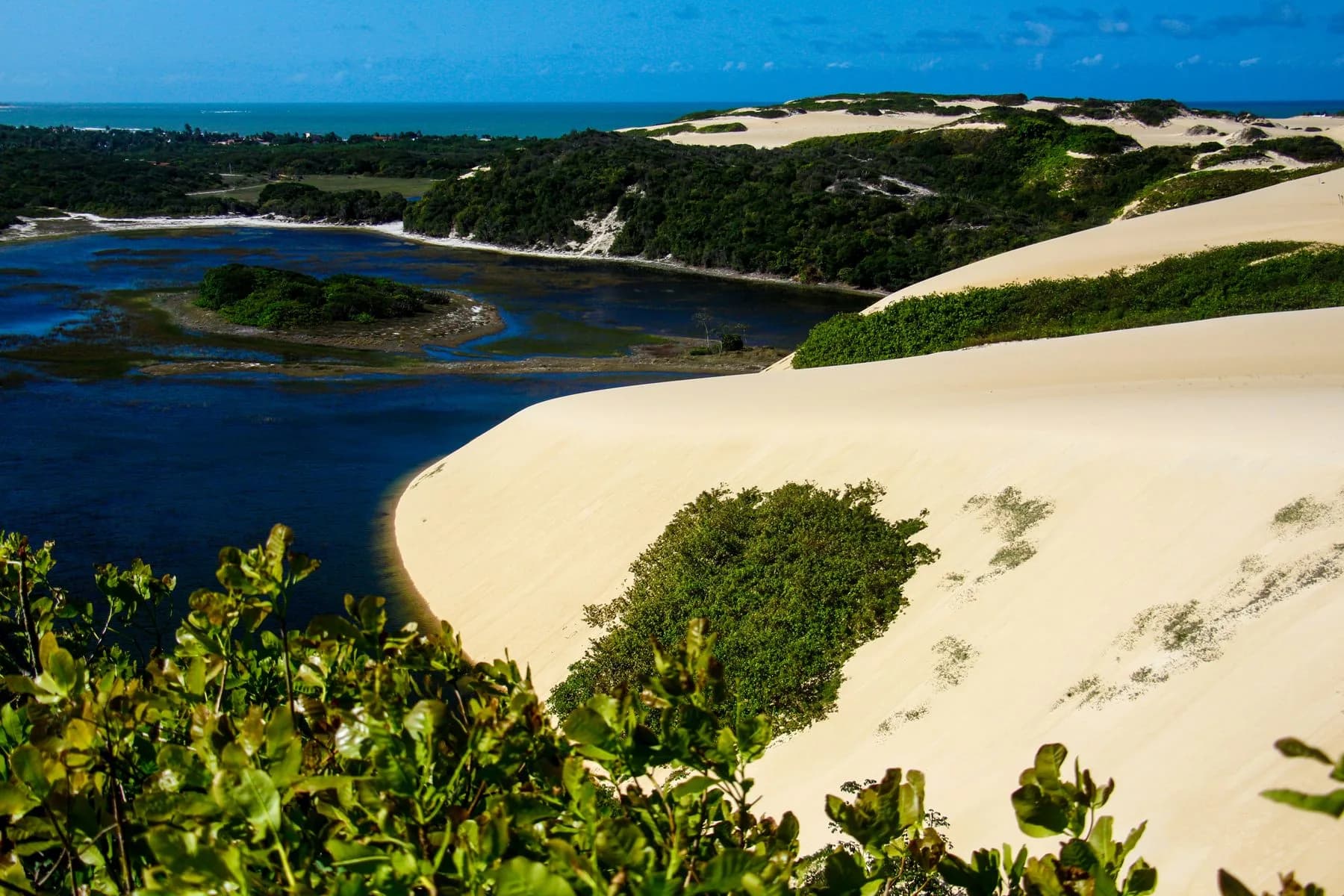 Paisagem de Genipabu com lagoa, dunas de areia e o mar ao fundo