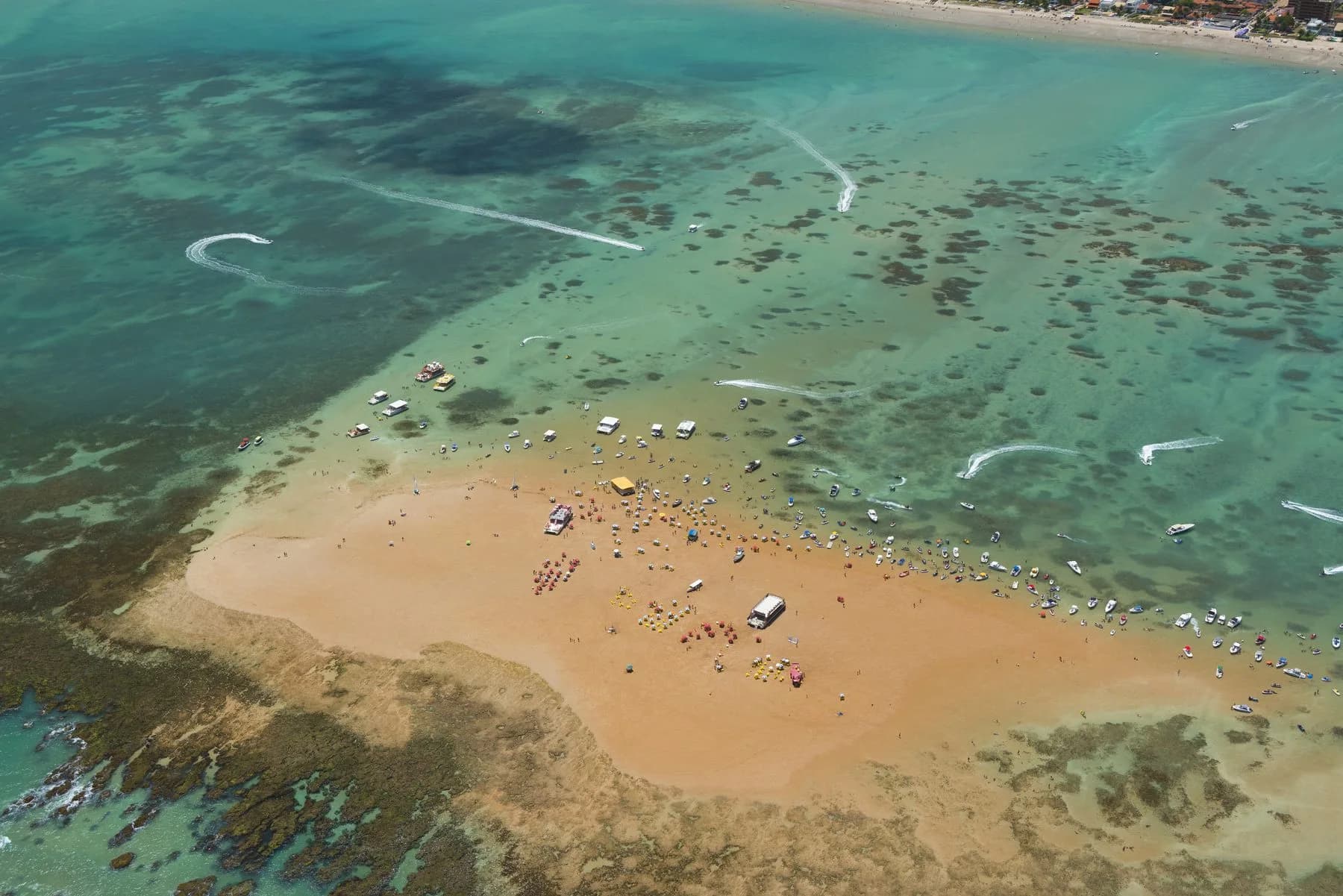 Ilha de Areia Vermelha reúne banhistas e barcos em águas rasas durante o passeio de catamarã
