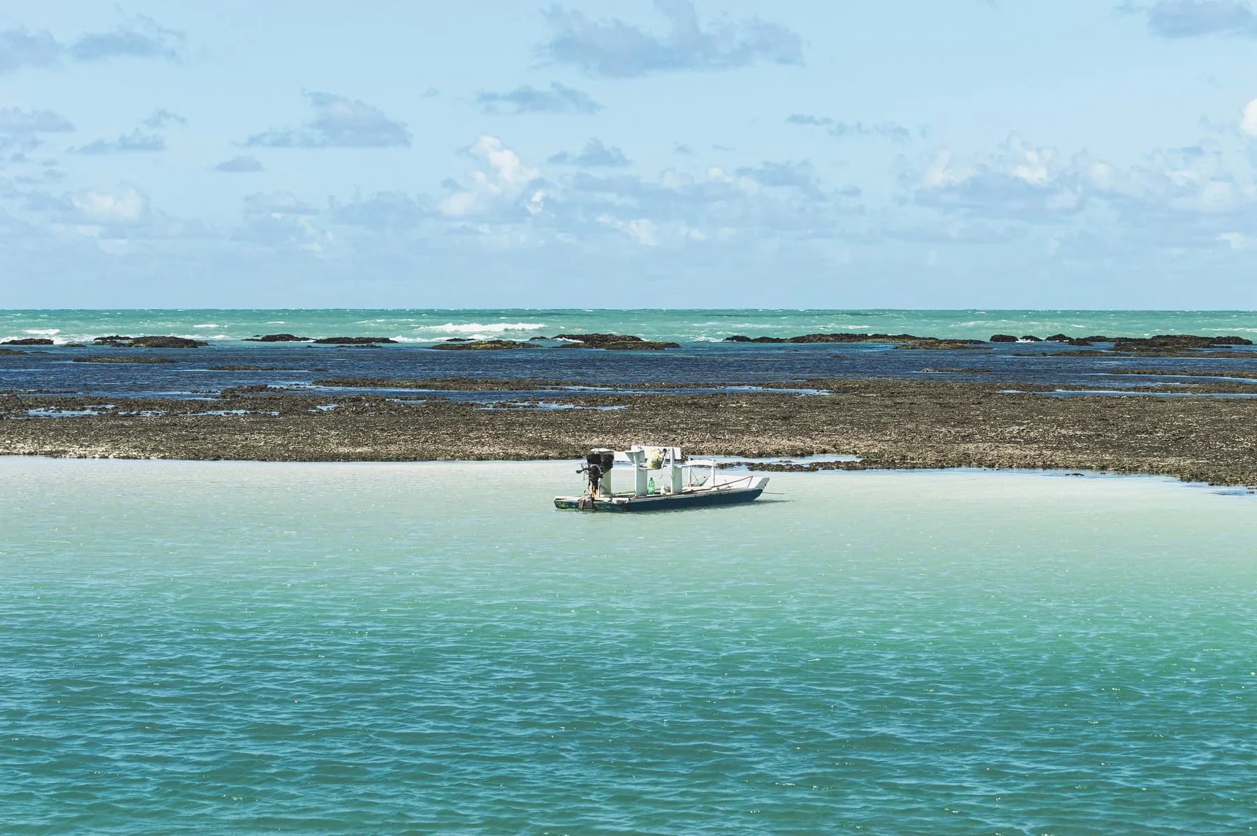 Maragogi no passeio de mergulho, com barco diante de recifes rasos