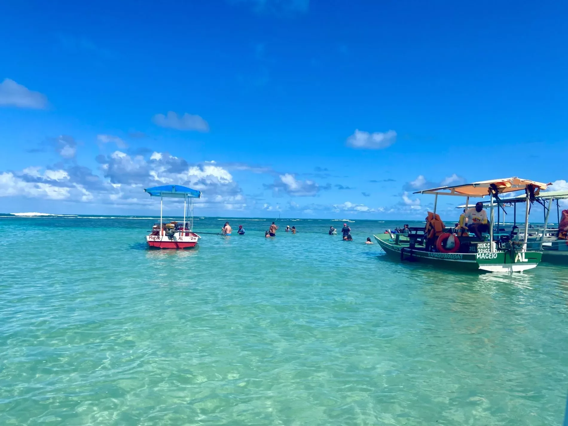 Jangadas e banhistas nas piscinas naturais do passeio em São Miguel dos Milagres