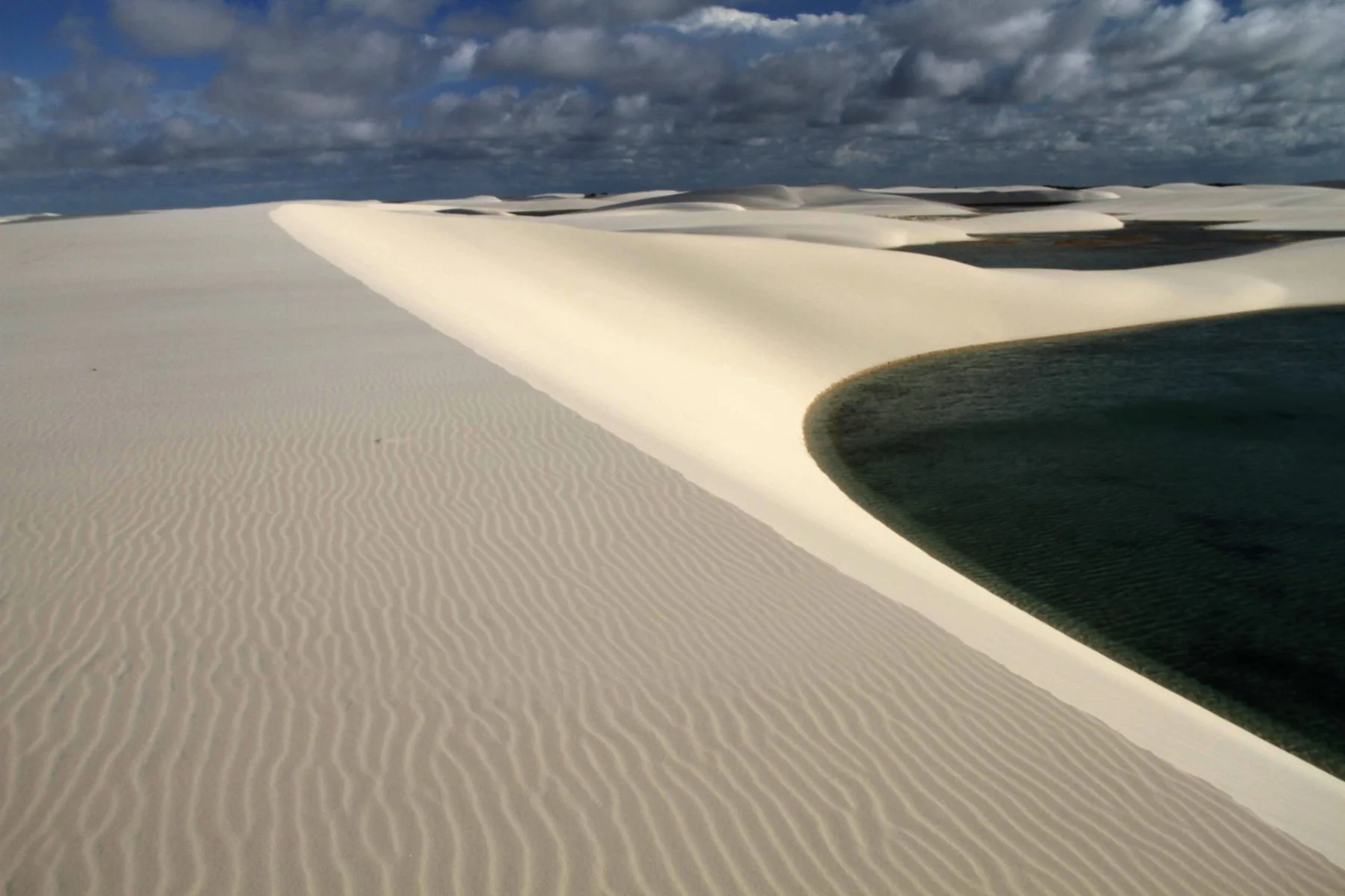 Passeio Lagoa da Gaivota em Santo Amaro, com dunas onduladas junto a uma lagoa escura